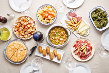 Traditional Spanish Dishes With Empty Glasses On Table