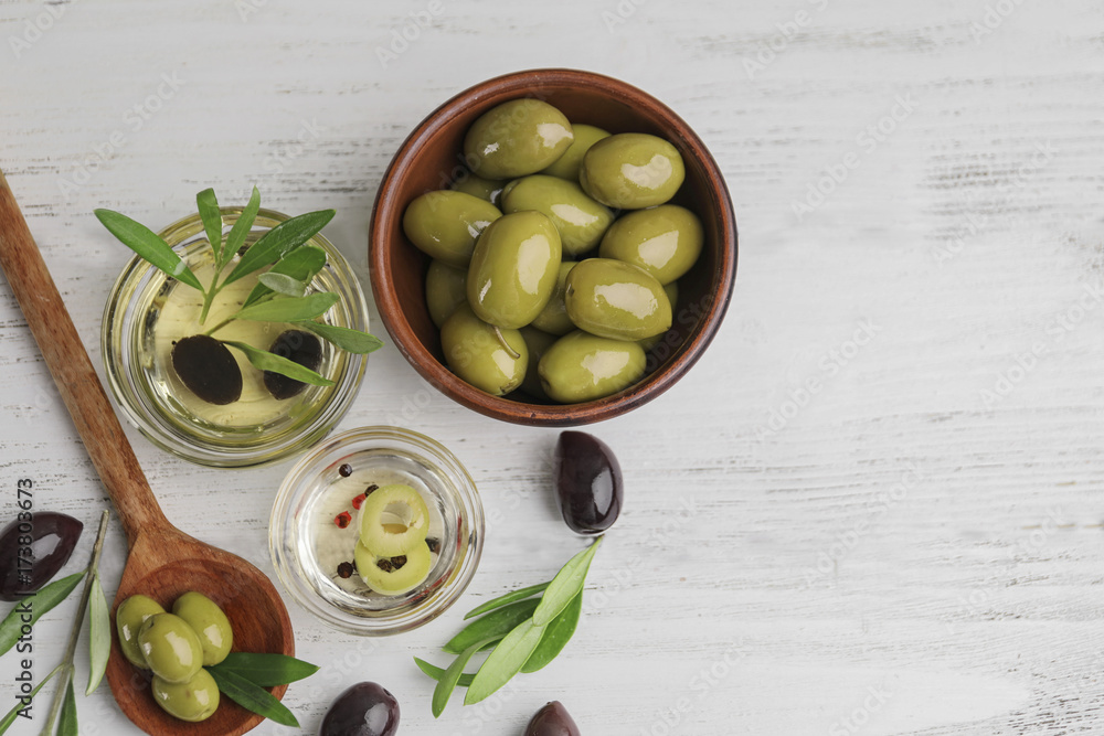 Composition with healthy olives and oil on wooden table