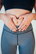 © Susana Ramirez/Stocksy - Healthy woman making a heart with her hands on her belly