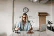 © Nicole Mason/Stocksy - young woman stamping logo on paper in work space