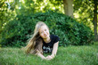 © Nestyda - happy smiling girl lies on the grass in the park outdoor