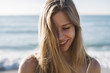 © WAVE/Stocksy - Happy and smiling woman portrait at the beach
