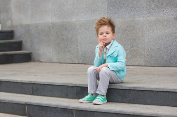 Wall Mural - Fashion kid posing near gray wall