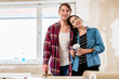 © Kzenon - Portrait of a happy young couple wearing casual clothes while holding tools for home remodeling after moving in together