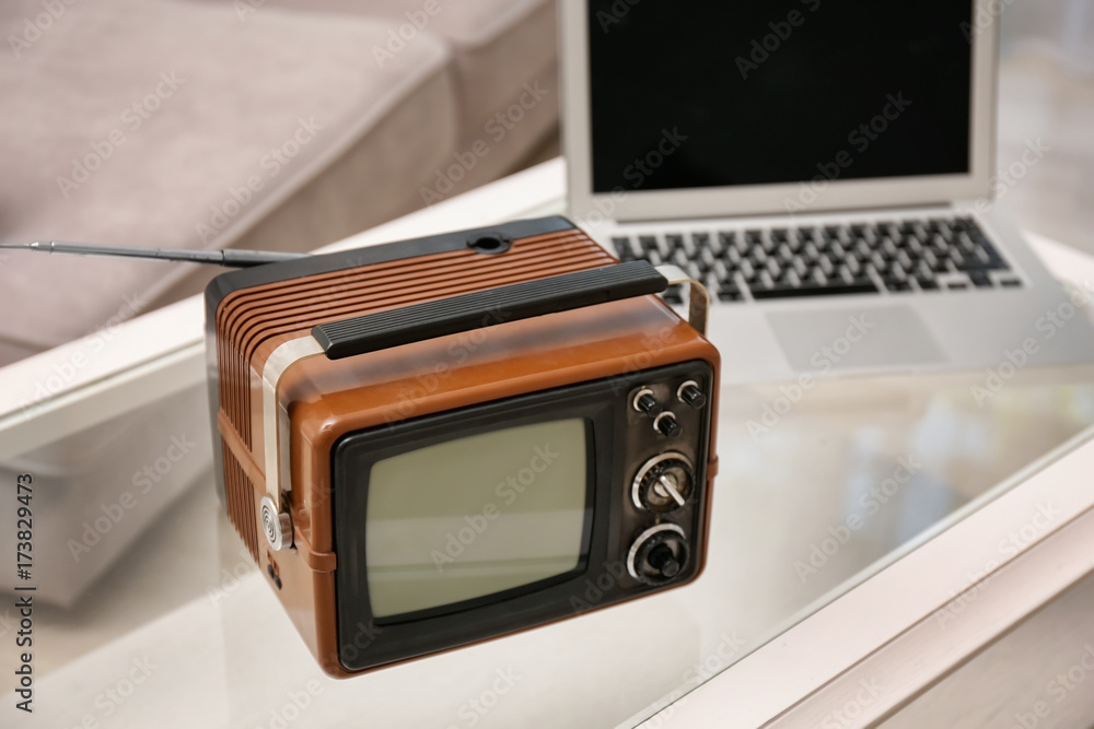 Old vintage TV and laptop on table in room