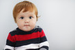 Portrait of cute one year old boy with ginger hair and blue eyes