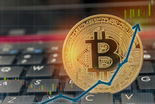 Bitcoin Currency Rising Concept On Laptop Keyboard With Up Arrow Chart And Golden Bitcoin.  Copyspace For Text.