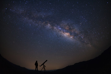 Wall Mural - silhouette of a standing man with telescope watching the wilky way galaxy