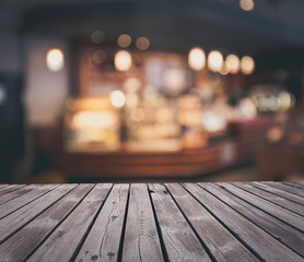 Wooden table top grunge surface over blur cafe interior background