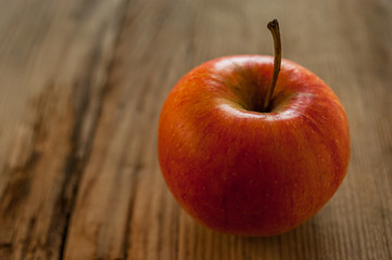 Ripe red apple on rustic dark wooden table