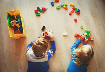 Wall Mural - little boy and girl play with plastic blocks