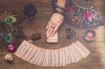 Wall Mural - fortune teller female hand and tarot cards on wooden table. fortune teller divination.