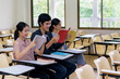 © WS Films - Group of three students reading book together in classroom