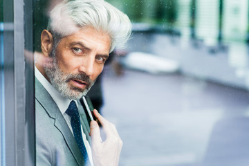 Wall Mural - Mature businessman in the office looking out.