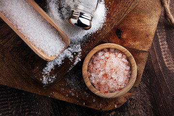 Salt Shaker and salt on wooden table.