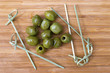 Green olives on wooden background.