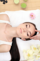 Cute young woman enjoying during a skin care treatment at a spa.