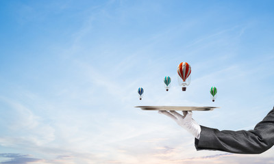 Wall Mural - Hand of waiter presenting balloons on tray.