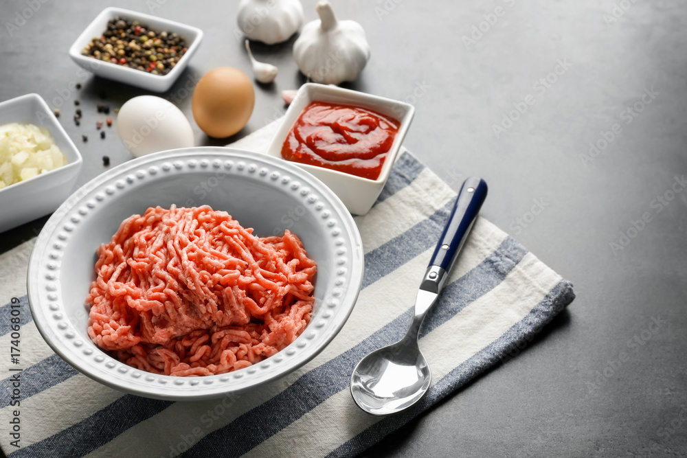 Plate with fresh raw minced meat on table