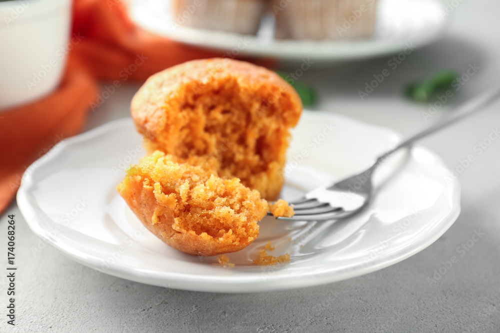 Plate with delicious carrot muffin on table