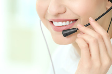 Poster - Young woman with headset on blurred background, closeup