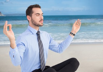 Canvas Print - Business man meditating against beach