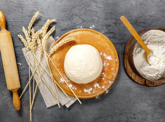 Poster - Fresh raw dough on dark surface in bakery, top view