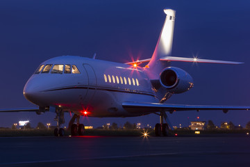 Large modern private business jet ready to take off at night