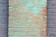 Green And Red Washed Paint On A Brick Column On The Face Of A Purple Painted Wall
