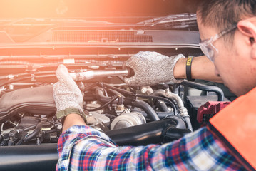 Wall Mural - The asian technician repairing or modify the car's engine in the garage. the concept of automotive, repairing, mechanical, vehicle and technology.