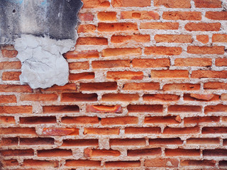 Old weathered crushed broken red long brick wall background with white concrete line grooves and part of grey cracked cement at the corner