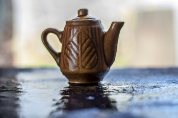 Small brown toy container on wet surface.