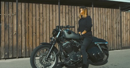 Wall Mural - CINEMAGRAPH - seamless loop.Outdoor lifestyle portrait of sexy biker girl wearing leather jacket sits on a modern motorcycle. 4K UHD