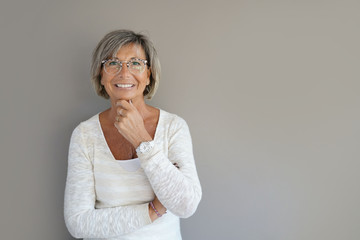 Wall Mural - Portrait of senior woman with eyeglasses on grey background