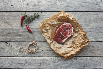 Sticker - Raw beef steak on dark wooden table background, top view