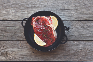 Sticker - Raw beef steak on dark wooden table background, top view