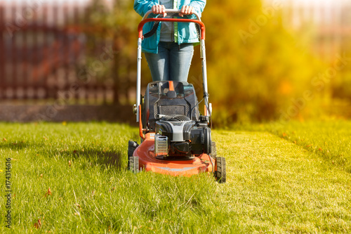 Pinturas sobre lienzo  woman working with a lawnmower in the garden