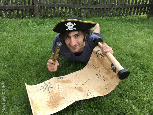 Plakat Pirat z mapą skarbów leżąc na trawie