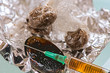 Wraps of brown drugs with a spoon and syringe on foil