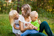 © justesfir - Family outdoors, mother and her son and daughter together playing