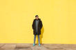 © BONNINSTUDIO/Stocksy - Portrait of an asian tattooed man standing in front of a yellow wall.