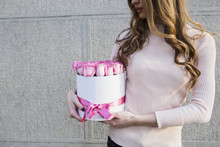 Young Woman Holding A Box Full Of Pink Roses