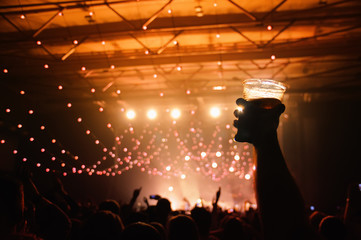 Wall Mural - Silhouette of a hand holding a beer in a concert