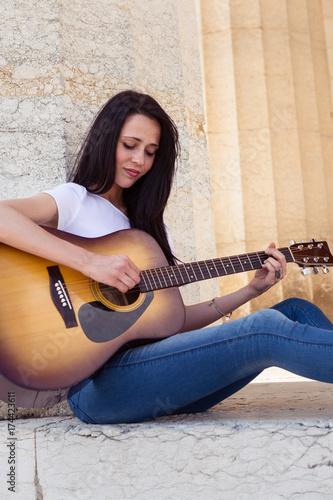 Plakat Piękna uśmiechnięta kobieta bawić się gitarę akustyczną
