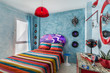 Vintage bedroom with a 60s clock, desk, records,mirror, colorful bedcover and retro lamp