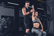 © LIGHTFIELD STUDIOS - trainer helping woman to exercise with dumbbell