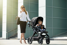 Business Woman Talking On The Phone And Pushing Baby Stroller