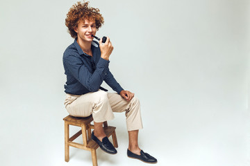 Wall Mural - Positive retro man dressed in shirt sitting and posing