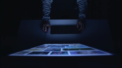 Designer skims his sketches in a dark room