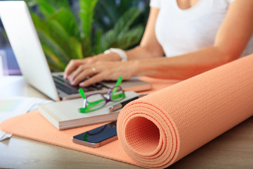 Woman and an exercise mat in an office background